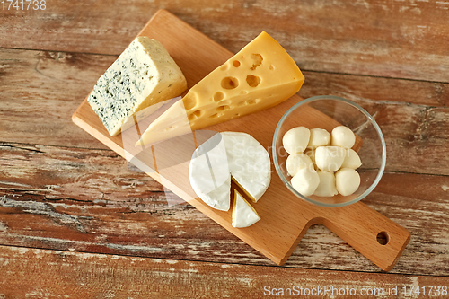 Image of different kinds of cheese on wooden cutting board