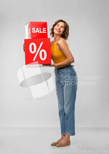 Image of happy smiling young woman with sale signs