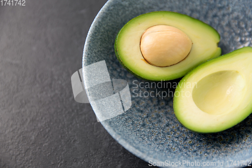 Image of close up of ripe avocado with bone in ceramic bowl