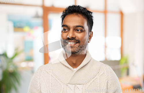 Image of indian man in sweater over office background