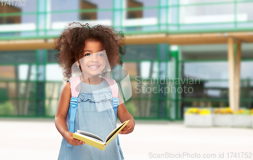 Image of happy little african girl with book and backpack