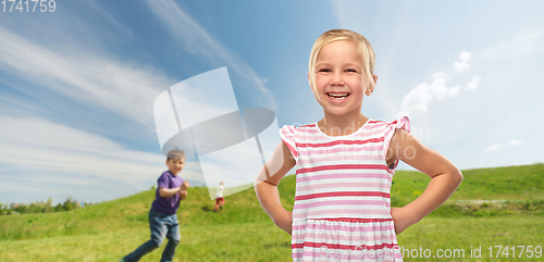 Image of smiling little girl in striped dress outdoors