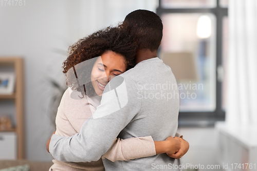 Image of happy african american couple hugging at home