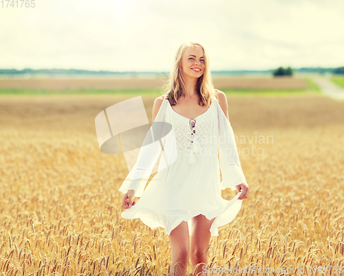 Image of smiling young woman in white dress on cereal field