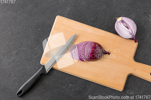 Image of red onion and kitchen knife on cutting board