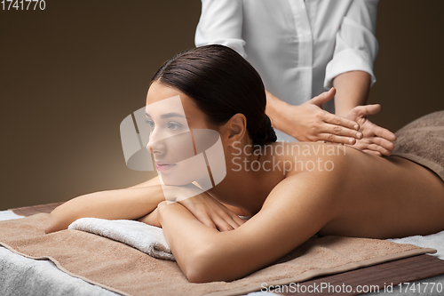 Image of woman lying and having back massage at spa