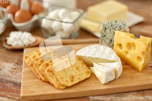 Image of crackers, cheese and other food on wooden board