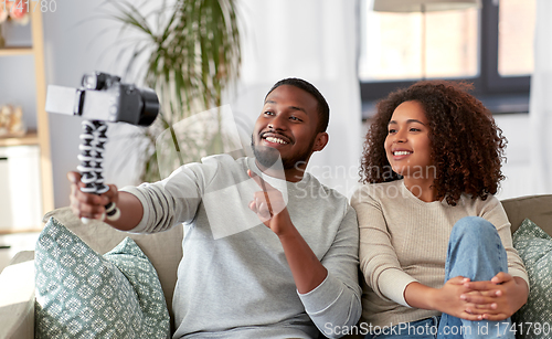 Image of couple of video bloggers with camera at home