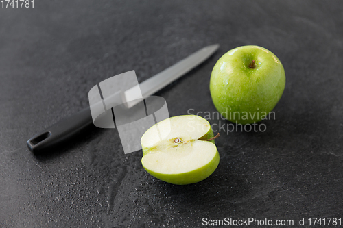 Image of green apples and kitchen knife on slate background