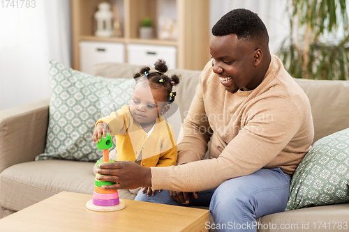 Image of african family playing with baby daughter at home