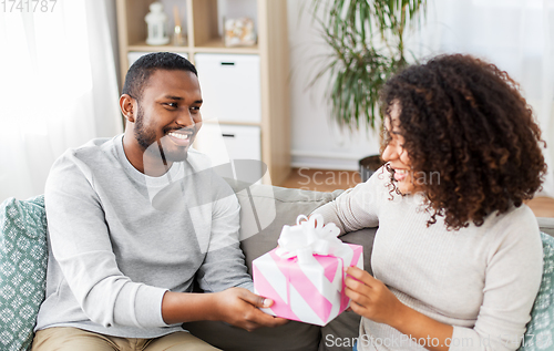 Image of happy couple with gift at home