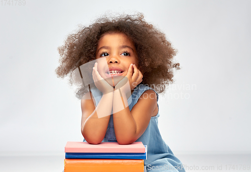 Image of smiling little african american girl with books