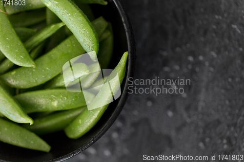 Image of peas in bowl on wet slate stone background