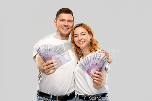 Image of happy couple in white t-shirts with euro money