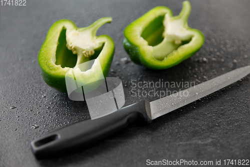 Image of green pepper and kitchen knife on slate background