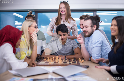 Image of multiethnic group of business people playing chess