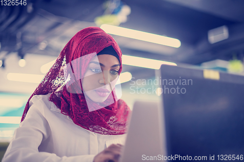 Image of black muslim business woman ,working on laptop computer
