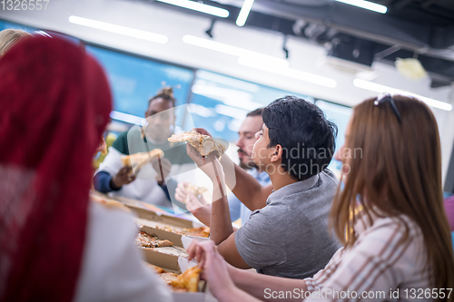 Image of multiethnic business team eating pizza