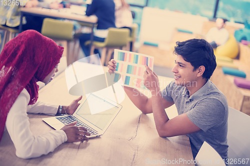Image of black muslim business woman having a meeting with her indian mal