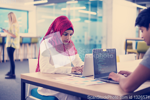 Image of black muslim business woman having a meeting with her indian mal