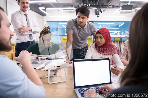 Image of multiethnic business team learning about drone technology