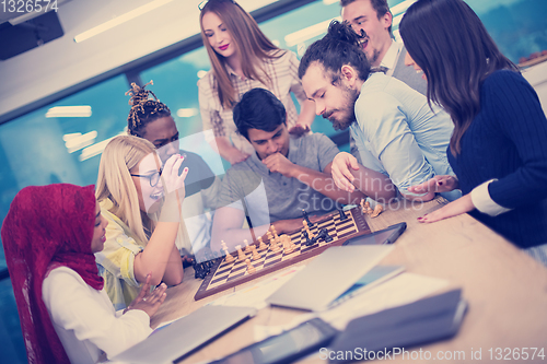 Image of multiethnic group of business people playing chess