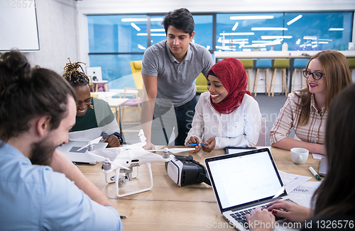 Image of multiethnic business team learning about drone technology