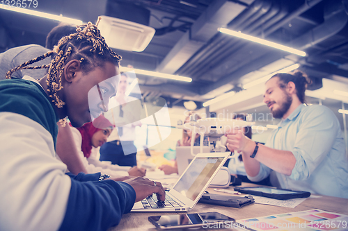 Image of multiethnic business team learning about drone technology