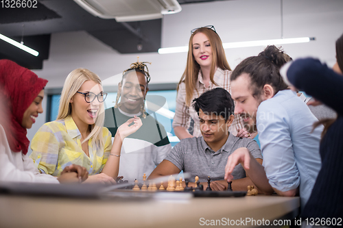 Image of multiethnic group of business people playing chess