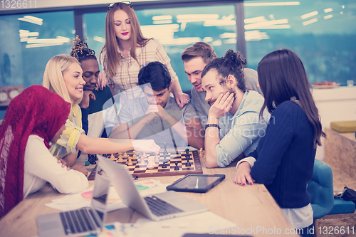 Image of multiethnic group of business people playing chess