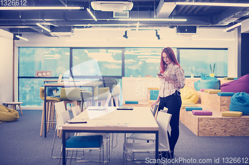 Image of redhead businesswoman using mobile phone at office