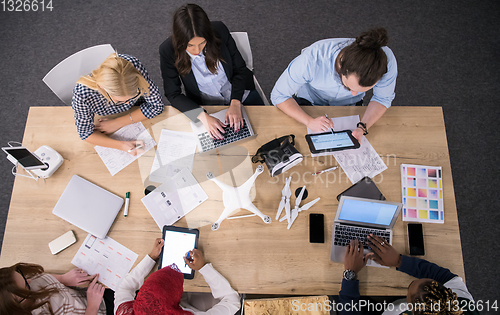 Image of top view of multiethnic business team learning about drone techn