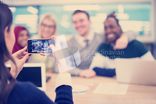 Image of businesswoman using mobile phone for taking photo