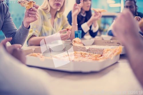 Image of multiethnic business team eating pizza