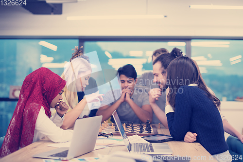 Image of multiethnic group of business people playing chess