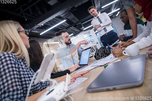 Image of multiethnic business team learning about drone technology