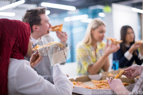 Image of multiethnic business team eating pizza