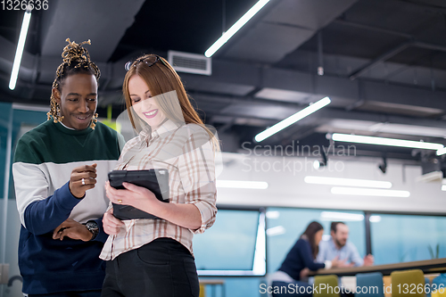 Image of multiethnic business couple using a tablet computer