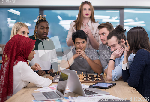 Image of multiethnic group of business people playing chess