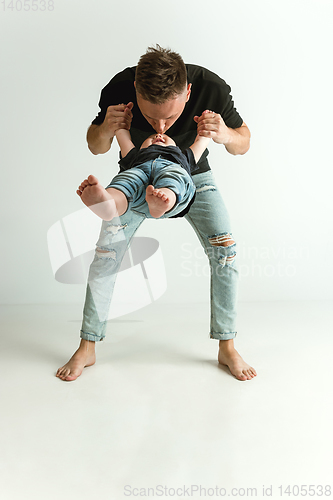 Image of Happy father holding adorable little son and smiling