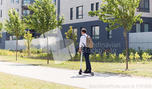 Image of businessman with backpack riding electric scooter