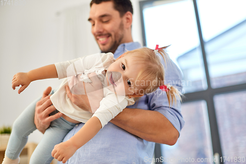 Image of father with little baby daughter at home