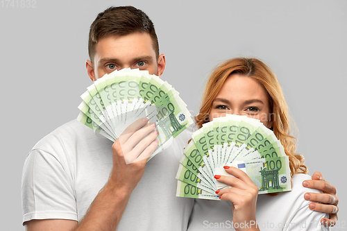 Image of happy couple in white t-shirts with euro money