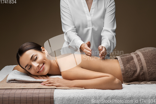 Image of woman lying and having back massage at spa