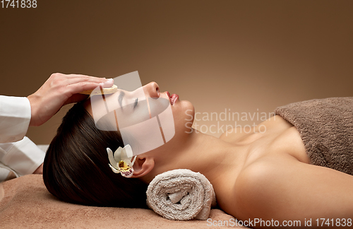 Image of close up of woman having face massage in spa