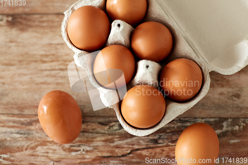 Image of close up of eggs in cardboard box on wooden table