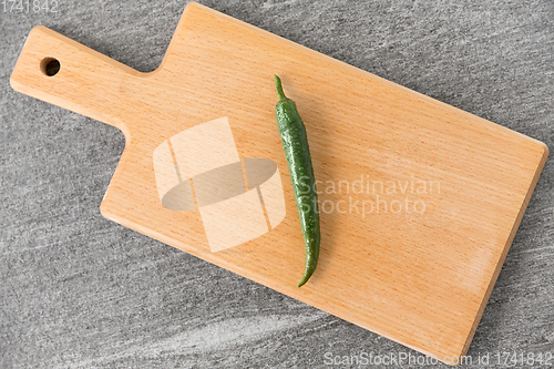 Image of green chili pepper on wooden cutting board