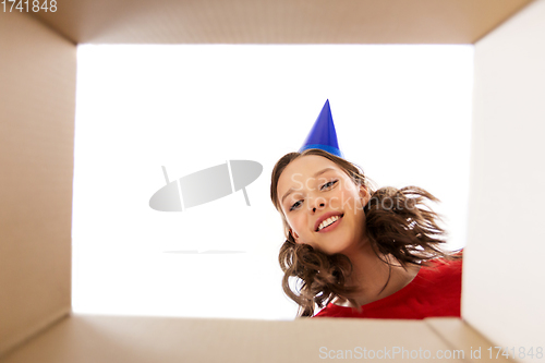 Image of happy young woman looking into open birthday gift