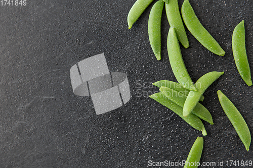 Image of peas on wet slate stone background