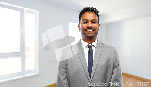 Image of smiling indian man realtor at new apartment